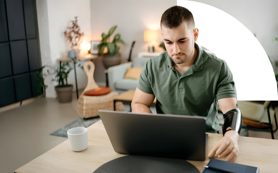 Desarrollador con prótesis tecnológica trabajando en laptop en ambiente moderno