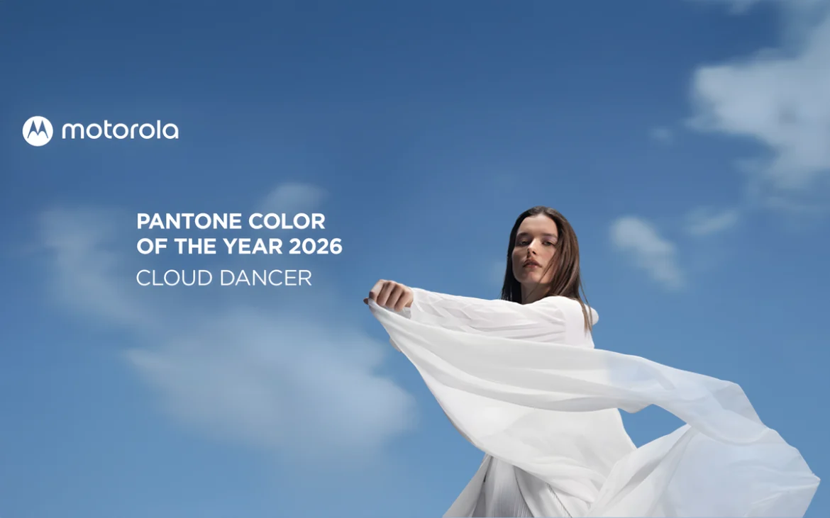 Mujer vestida de blanco fluido bajo un cielo azul representa Cloud Dancer, el Pantone Color of the Year 2026 que Motorola adopta para su próxima edición especial.